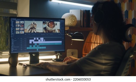 Guy in headphones editing video with astronauts for space blog in professional program while working remotely on computer at home - Shutterstock ID 2206033053