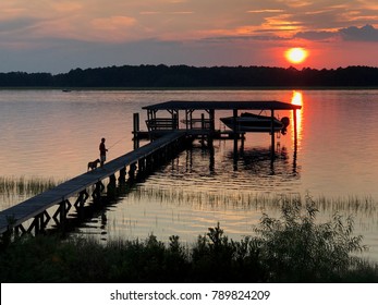 Guy And His Dog Fishing During A Charleston, SC Sunset