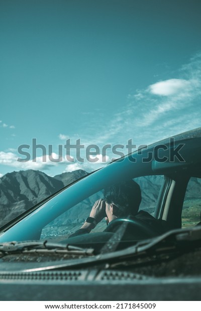 A guy holding a\
binocular inside a car