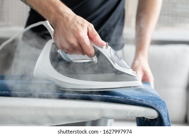 A Guy Ironing Clothes Before Going Outside.