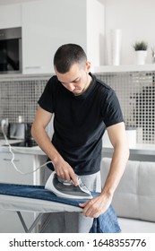 A Guy Ironing Clothes Before Going Outside.