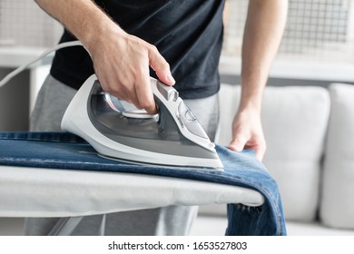 A Guy Ironing Clothes Before Going Outside.