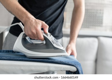 A Guy Ironing Clothes Before Going Outside.