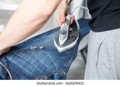 A Guy Ironing Clothes Before Going Outside.