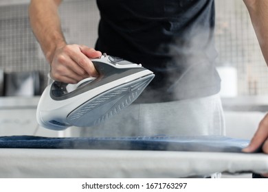 A Guy Ironing Clothes Before Going Outside.