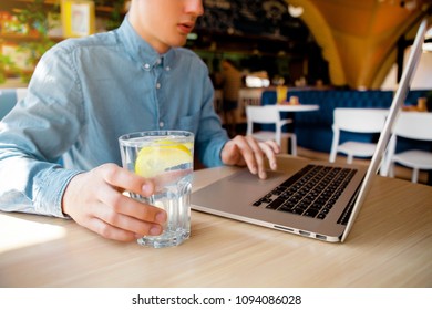 the guy with the laptop and a glass of water with lemon - Powered by Shutterstock