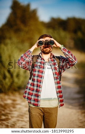 Similar – Man observing something through binoculars