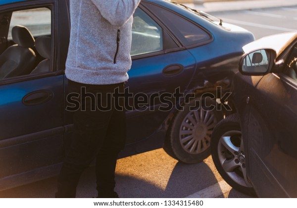 A guy is looking nervous after the car accident on\
the road