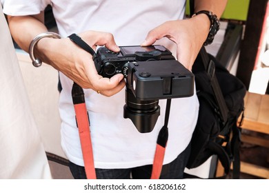 A guy looks into digital camera screen.