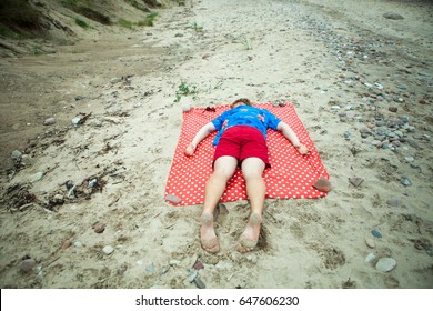 Guy lying on a beach with face down