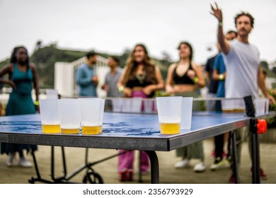 Guy Making the Gesture of Throwing the Ball into the Rival's Cups in a Beer Pong Game During a Friends Party - Powered by Shutterstock