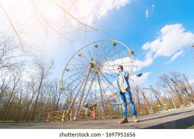 guy on the background of an empty ferris wheel in the park speaks on the phone