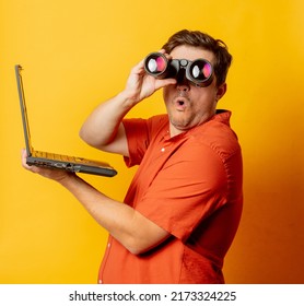 Guy In Orange Shirt Watch In Binoculars And Laptop Computer On Yellow Background