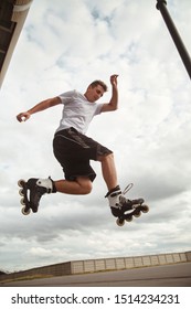 The Guy Performs A Roller Skate Jump Trick On The Road.