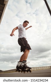 The Guy Performs A Roller Skate Jump Trick On The Road.