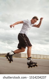 The Guy Performs A Roller Skate Jump Trick On The Road.