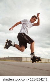 The Guy Performs A Roller Skate Jump Trick On The Road.