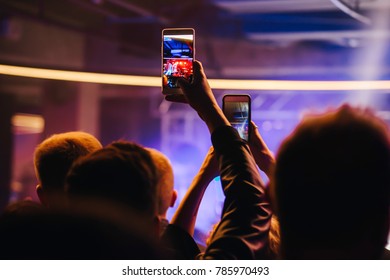 A Guy With A Phone At A Concert In A Crowd Takes A Video On His Phone