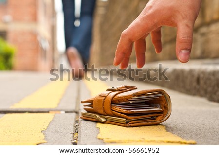 guy picking up a lost purce/wallet