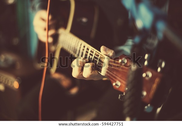 A guy playing an acoustic guitar. Fragment. Focus on\
the hand
