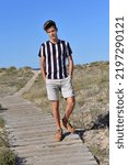 Guy posing on the beach alone, surrounded by Mediterranean veget
