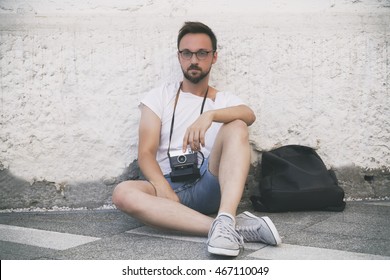 Guy posing outdoors with old camera.