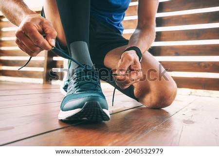Guy preparing for running and laces up on the sneakers