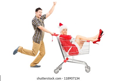 Guy pushing a woman wearing christmas costume in a shopping cart isolated on white background - Shutterstock ID 118907134
