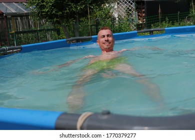 A Guy With A Red Mohawk Swims In The Pool.