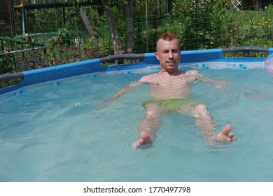 A Guy With A Red Mohawk Swims In The Pool.