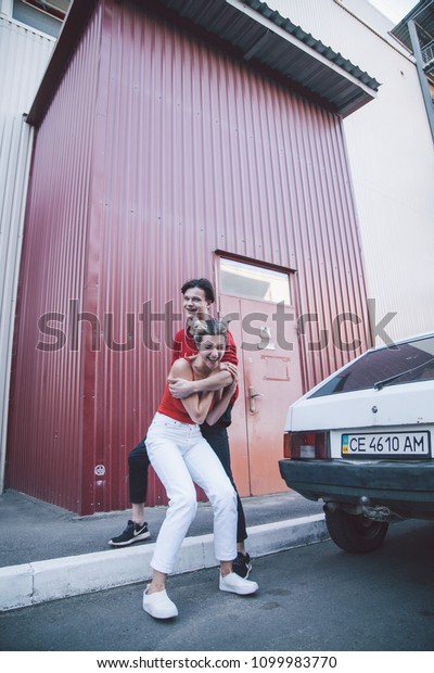 guy in red sweater and girl blonde in red shirt and\
white summer jeans
