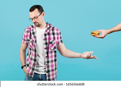 The Guy Reluctantly Agrees To Take Burger And Turns Away From The Person Who Offers Him Food