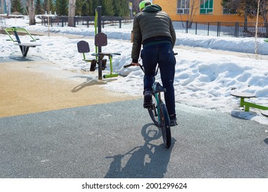 The Guy Is Riding A Bike. Snow Covered Earth. Russia, Ishimbay. 26.04.2021