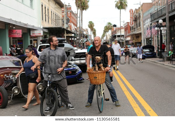 guy riding his bike with his dog and friend in the\
street at I love driving slow car show in ybor city Tampa, Florida\
July 8, 2018