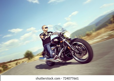 Guy riding a motorcycle on an open road