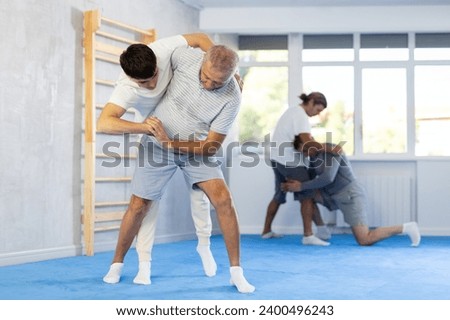 Guy and senior man sportsman in pair conduct training battle in oriental fighting technique. School of martial arts. Reinforcement strength of mind and body. Sport to max