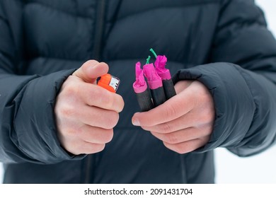 Guy Sets Fire to the Flash Noise Firecrackers Outdoors in Winter at Daytime. Loud and Dangerous New Year's Entertainment. Hooliganism with Pyrotechnics. Noise of Petards in Public Places