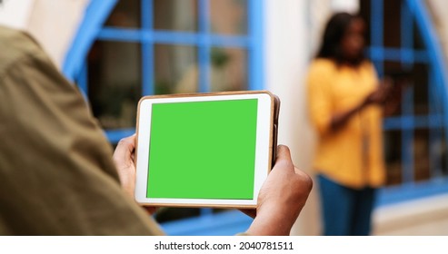 Guy Showing Tablet Green Screen Outdoors. Urban Environment. Man Hand Holding Tablet With Chroma Key. Back View Shot. Outdoor 