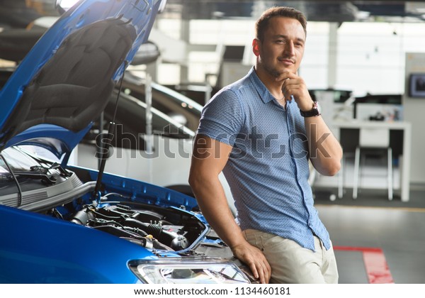 Guy is sitting on the front of the car. He is\
thinking how to buy new\
car.
