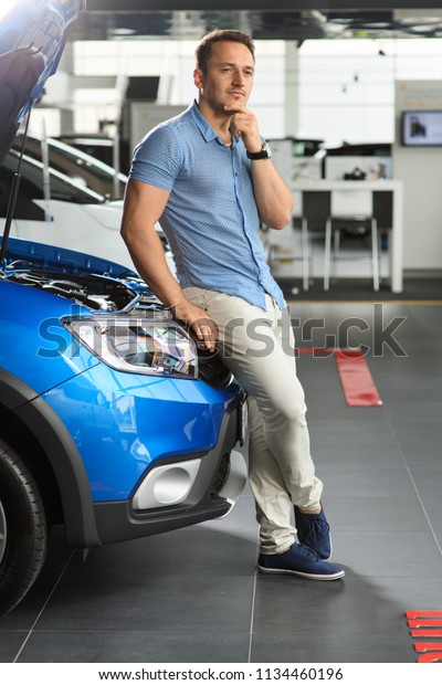 Guy is sitting on the front of the car. He is
thinking how to buy new
car.