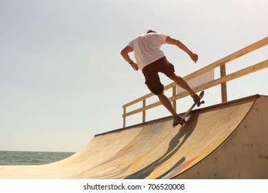 Guy Skateboarder Rides On A Ramp On A Sunny Day