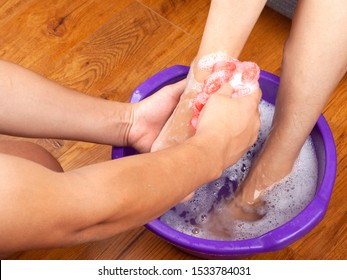 The Guy In The Spa Salon Made The Girl A Warm Foot Bath And Washes Her Feet With Natural And Fragrant Soap.aromatherapy For Legs