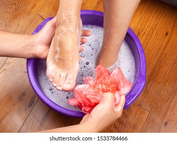 The Guy In The Spa Salon Made The Girl A Warm Foot Bath And Washes Her Feet With Natural And Fragrant Soap.aromatherapy For Legs