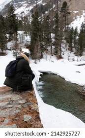 Guy Squatting At A Frozen Waterfall