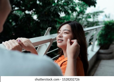 A Guy Squeeze His Girlfriend's Cheek After She Did It To Him.