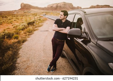 The Guy Is Standing By The Car And Looking At The Road. Traveler