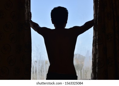 A Guy Standing at Wet Window
