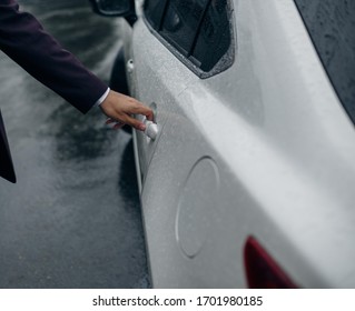 Guy In A Suit Is Opening A Car Door. Wet Automobile, Rain.