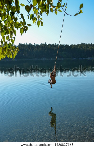 Guy Swinging On Rope Swing Into Stock Photo Edit Now