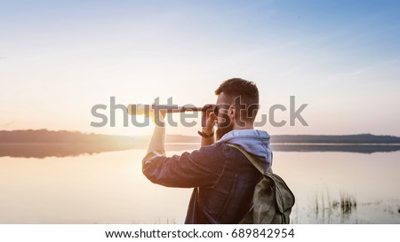 Guy with a telescope on nature sunset sun